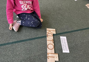 dziecko konstruuje litery i wyrazy z klocków- przygotowanie do nauki czytania i pisania